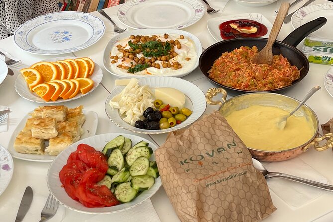 Authentic Turkish Antioch Breakfast with Local Sisters - Adding eggs with sucuk and simit to the table